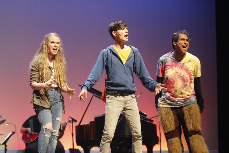 Electrifying Performance. Juniors Isabela Barry, Tanzil Philip and senior Alexander Athanasiou perform in Douglas Drama’s production of the concert version of “The Lightning Thief” on April 26. Photo by Mackenzie Quinn