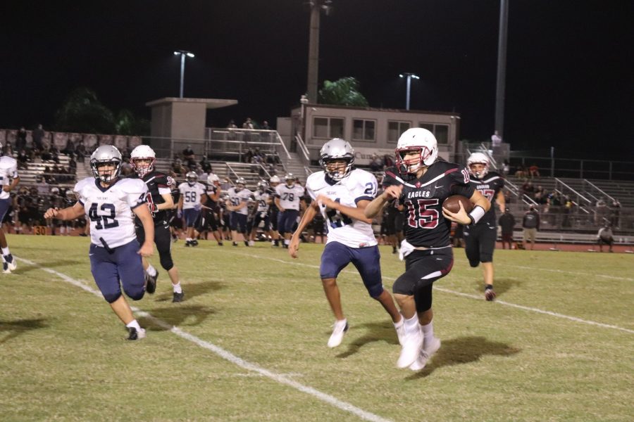 Eagles Quarterback Ryan Spallina (15) outruns the Trojans' defense to score a touchdown. Photo by Brooke Glaros.