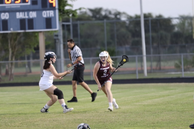 Freshman Gracyn Haynes, a women's varsity lacrosse player at MSD, clears the ball up the field after getting it back from the other team. Photo by Isabelly Silveira