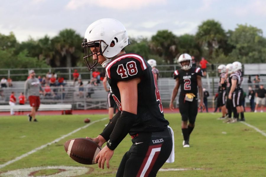 Freshman RJ Meis (48) prepares to snap back the ball while warming up and waiting for the game to start. Meis earned a spot on both the JV and varsity rosters.