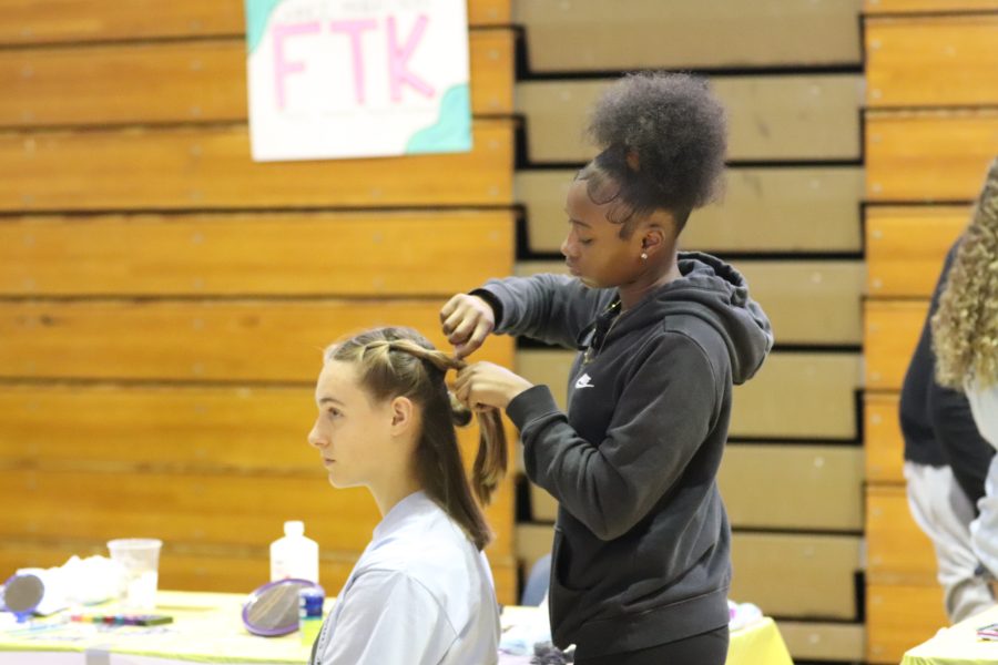 Grace Dykstra gets her hair bubble braided in the Hair Station. The money students used to buy a service like this went into the final tally of money that would be collected and showed at the end of the day to be donated to Nicklaus Children's Hospital.