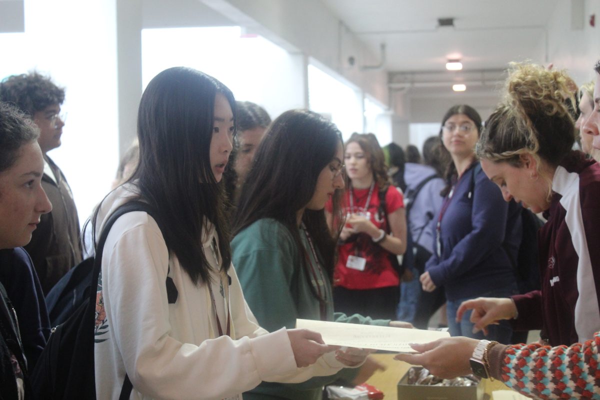 Sophomore Vivian Leung receives her honor roll certificate outside of MSD's Guidance Office on Nov. 11. The school requested that all students who made honor roll during the first quarter of the school year stop by to receive a cookie as a reward.