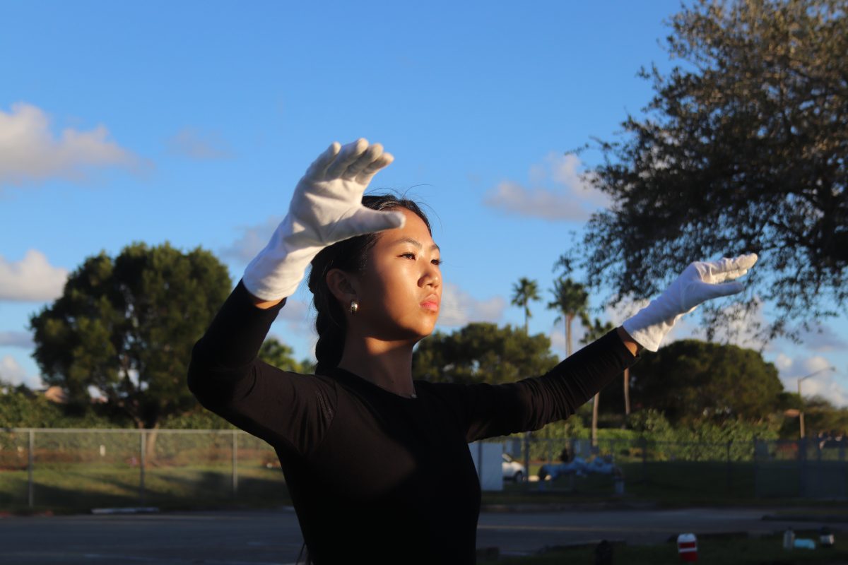 Follow the Leader. Drum Major Bella Wong conducts the marching band at rehearsals after school in the senior parking lot. The band rehearsed outside for four hours to ensure that they were prepared to perform in the Macy's Thanksgiving Day Parade.