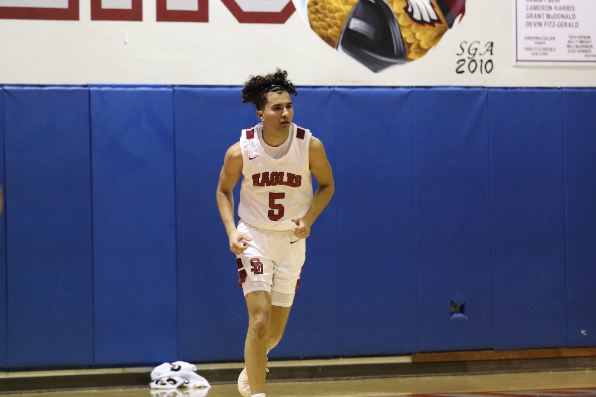 Captain and point guard Jack Servaites (5) runs down the basketball court, following a change in possession against Nova High School. The Eagles ended up winning the game by a final score of 59-52.